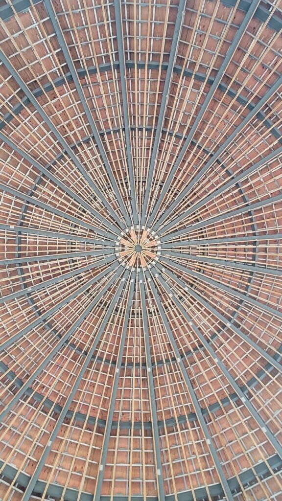 Radial timber and steel dome roof structure viewed from below