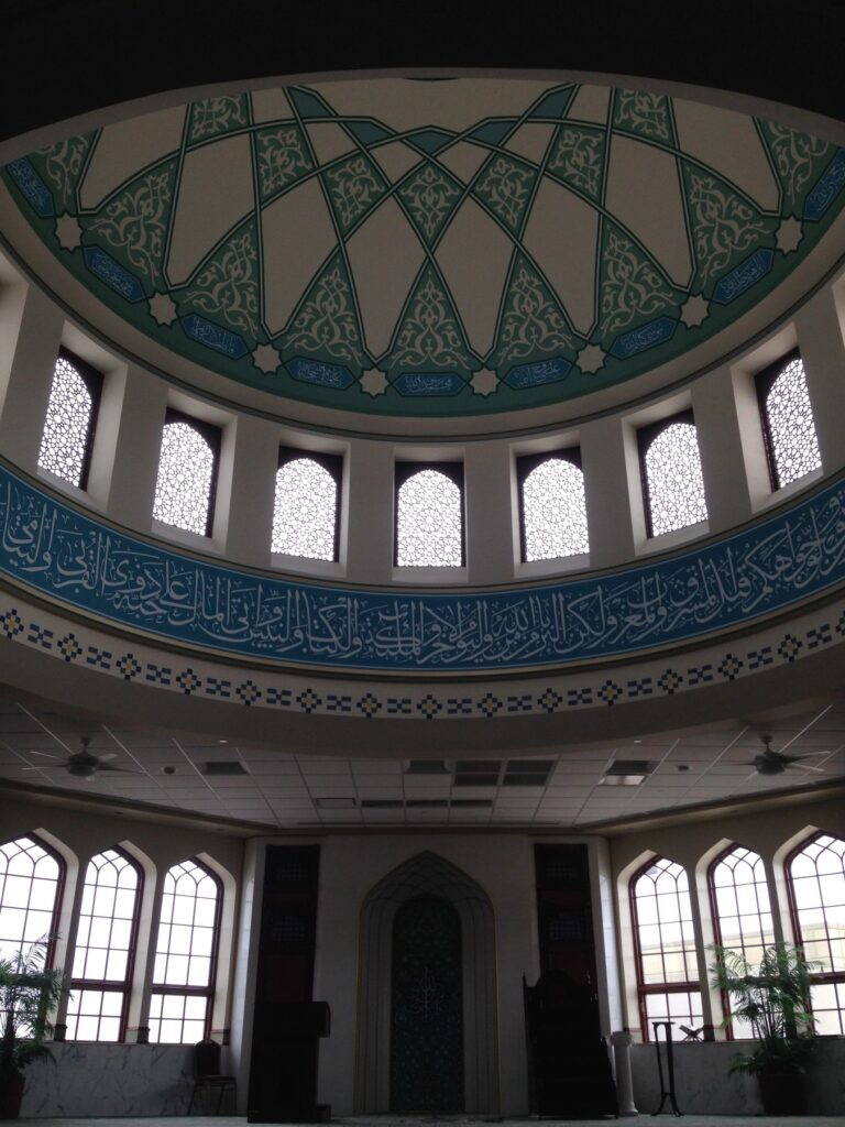 Completed prayer hall interior with decorated dome and arched windows